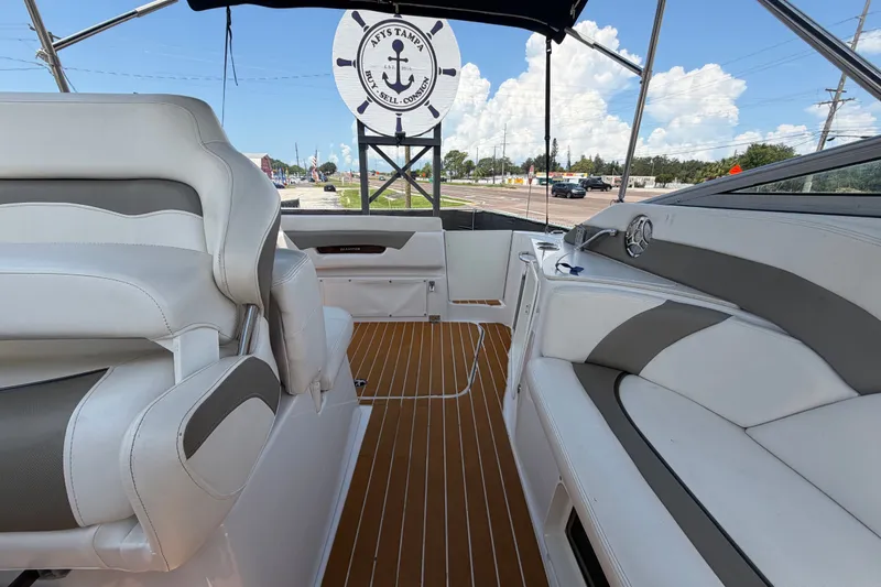 Slide: The Image of 2016 Glastron GS 259 boat interior with white seating and wood-style flooring. - 79