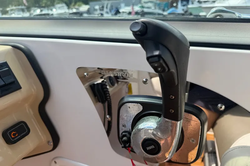Slide: The Image of Control panel of a 2016 Glastron GS 259 boat, featuring throttle and switches. - 37