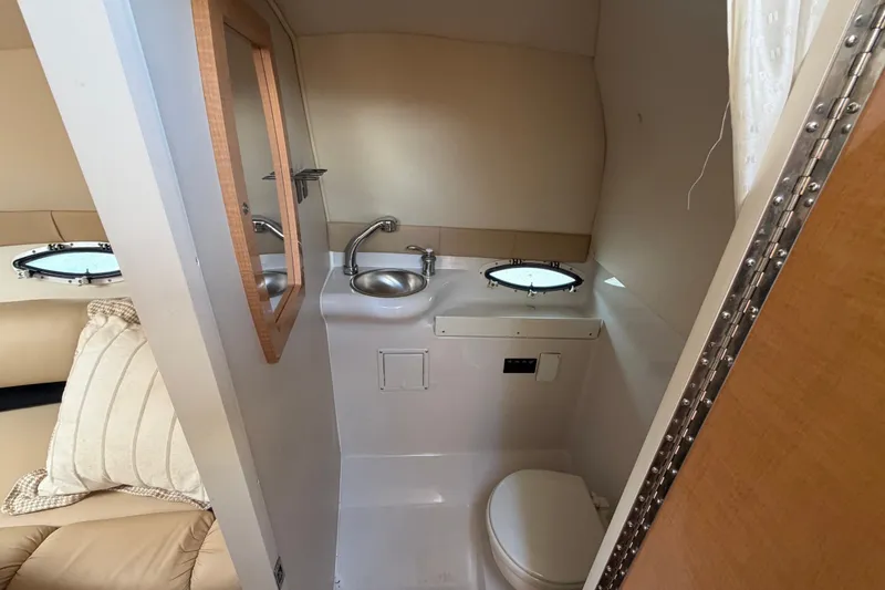 Slide: The Image of 2016 Glastron GS 259 boat interior bathroom with sink, toilet, and mirror. - 65