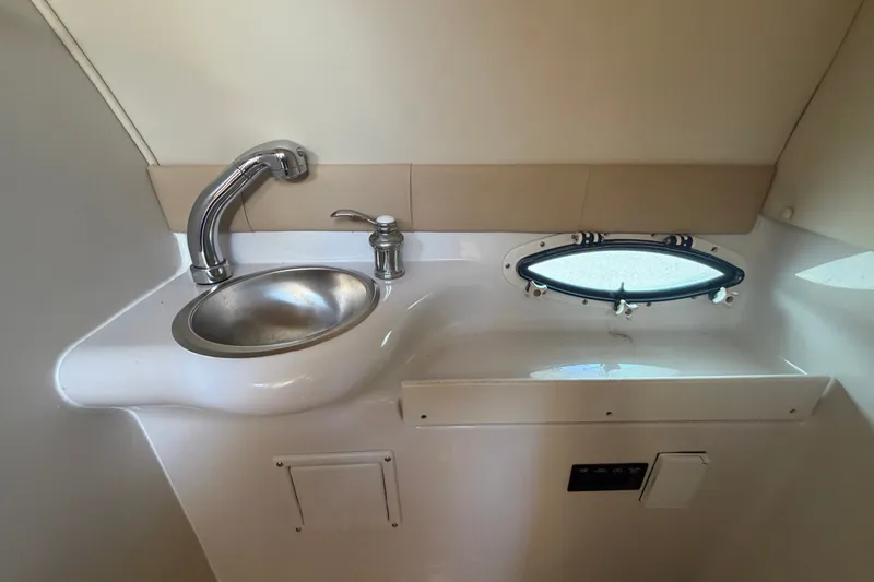 Slide: The Image of 2016 Glastron GS 259 boat interior with sink and porthole window. - 66