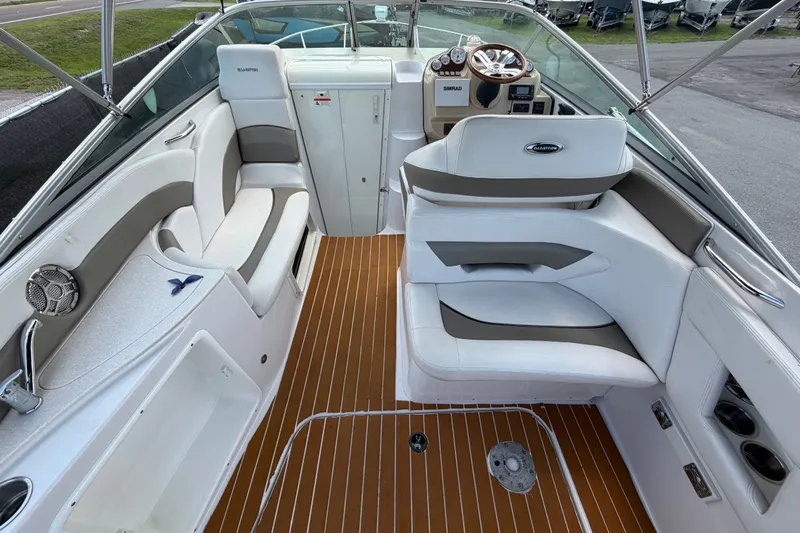 Slide: The Image of 2016 Glastron GS 259 boat interior with white seating and wood-style flooring. - 16