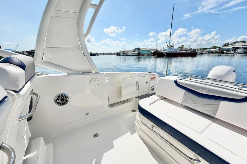Slide: The Image of 2021 Chaparral 280 OSX boat interior with seating, overlooking a serene marina. - 12