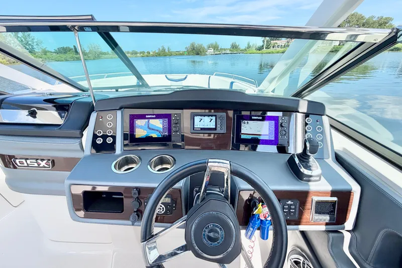 Slide: The Image of 2021 Chaparral 280 OSX boat dashboard with navigation screens and steering wheel. - 20