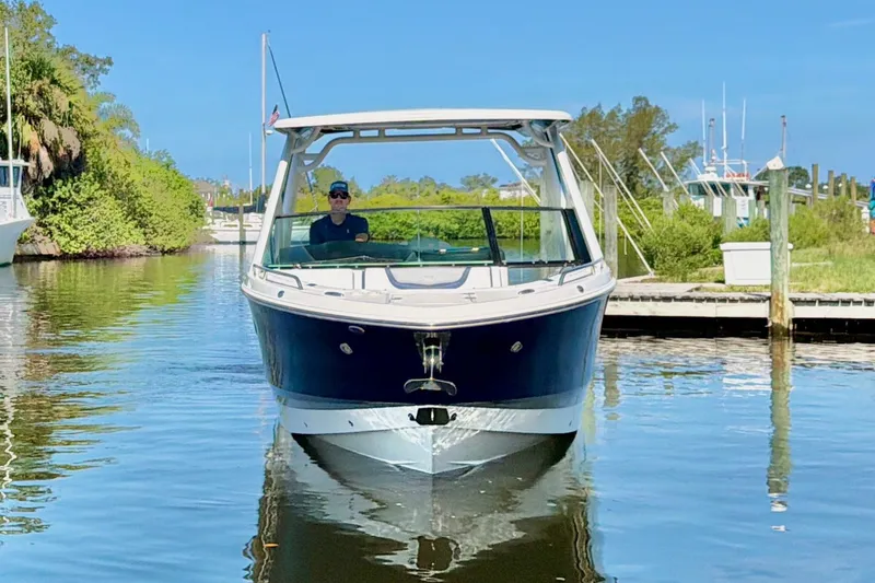 Slide: The Image of 2021 Chaparral 280 OSX boat cruising in a serene marina setting. - 5