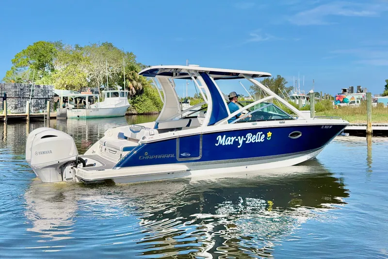 Slide: The Image of 2021 Chaparral 280 OSX boat named "Mar-y-Belle" on calm water near a dock. - 9