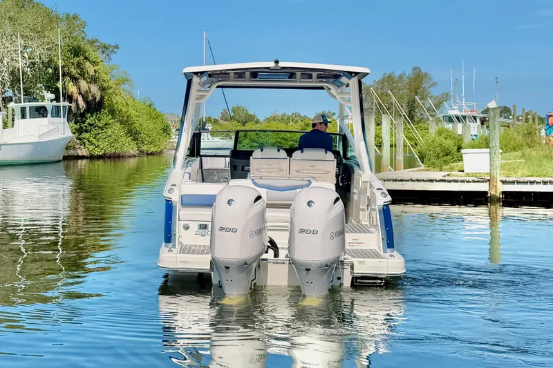 Slide: The Image of 2021 Chaparral 280 OSX boat with dual Yamaha engines on a calm waterway. - 8