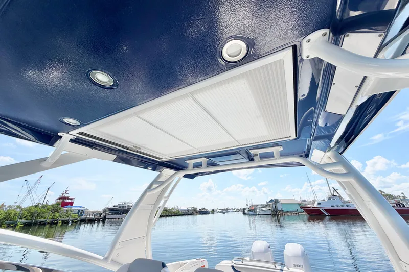 Slide: The Image of 2021 Chaparral 280 OSX boat canopy with integrated lighting, docked by a scenic waterfront. - 25