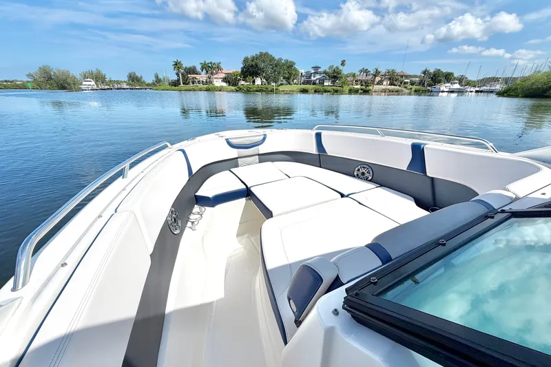 Slide: The Image of 2021 Chaparral 280 OSX boat interior with spacious seating on a sunny day. - 2