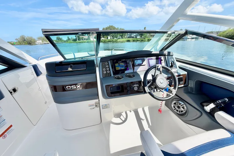 Slide: The Image of 2021 Chaparral 280 OSX boat cockpit with modern controls and scenic water view. - 17