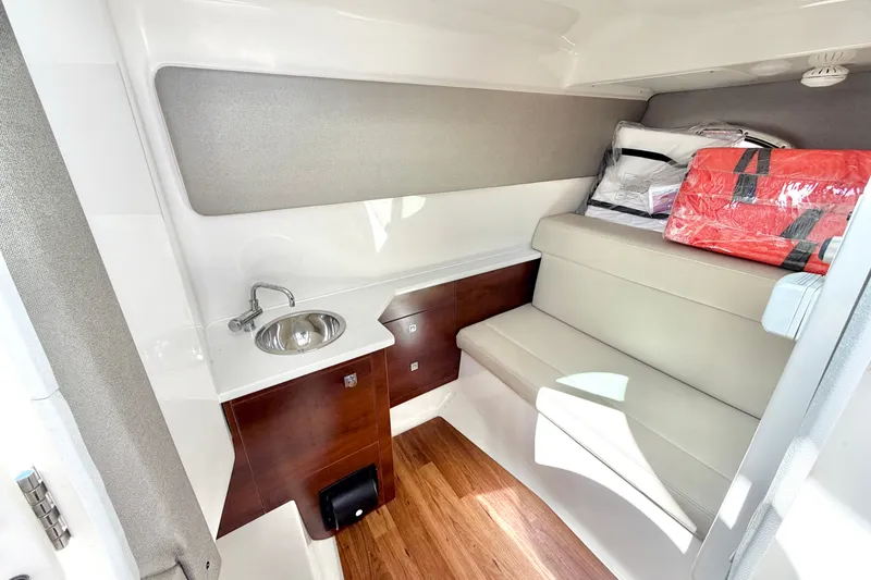 Slide: The Image of 2021 Chaparral 280 OSX cabin interior with sink, seating, and storage. - 23