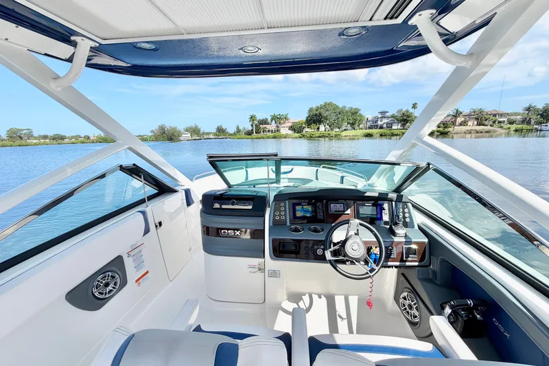 Slide: The Image of 2021 Chaparral 280 OSX boat interior with modern dashboard and scenic water view. - 16