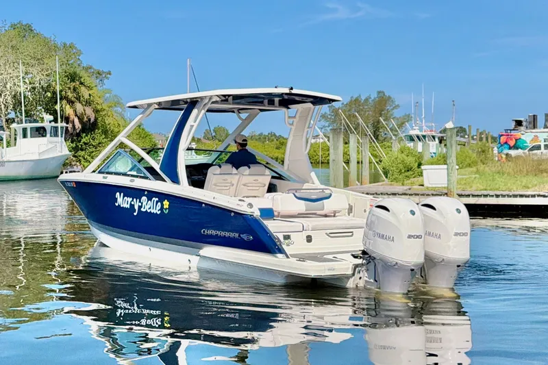 Slide: The Image of 2021 Chaparral 280 OSX boat with dual Yamaha engines docked on a sunny day. - 7