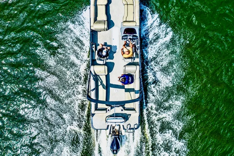 Slide: The Image of Aerial view of a 2022 Avalon Catalina Platinum Quad Lounge cruising over green water. - 13