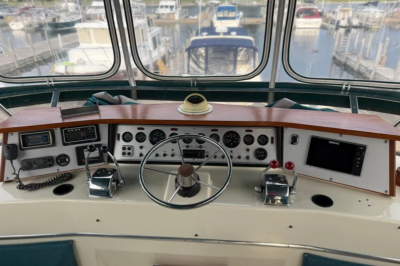 Slide: The Image of 1987 Chris-Craft 362 Catalina helm with steering wheel, gauges, and navigation equipment at marina. - 8