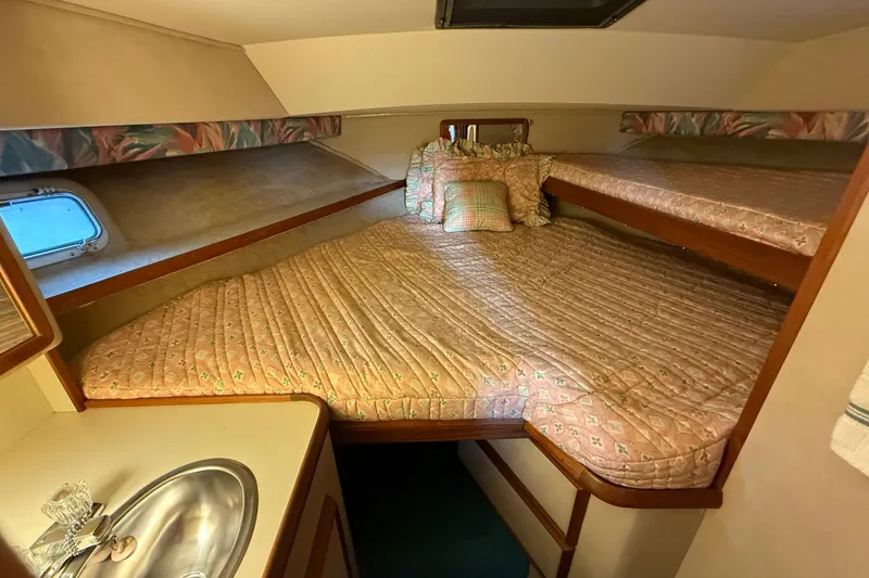 Slide: The Image of 1987 Chris-Craft 362 Catalina cabin interior with cozy bedding and compact sink area. - 18