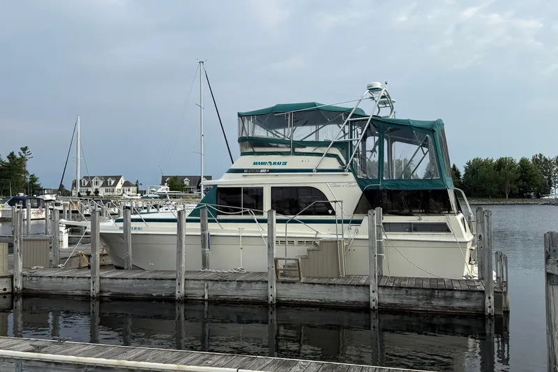 Slide: The Image of 1987 Chris-Craft 362 Catalina yacht docked at a marina with green canopy. - 1