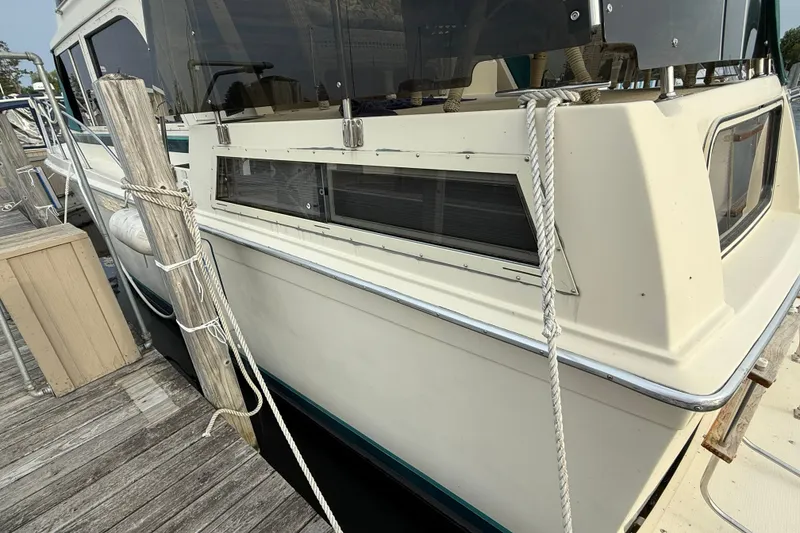 Slide: The Image of 1987 Chris-Craft 362 Catalina yacht docked, showcasing side view and mooring ropes. - 5