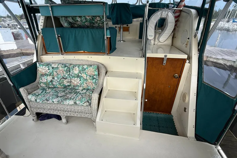 Slide: The Image of 1987 Chris-Craft 362 Catalina interior with floral wicker seating and steps to upper deck. - 12