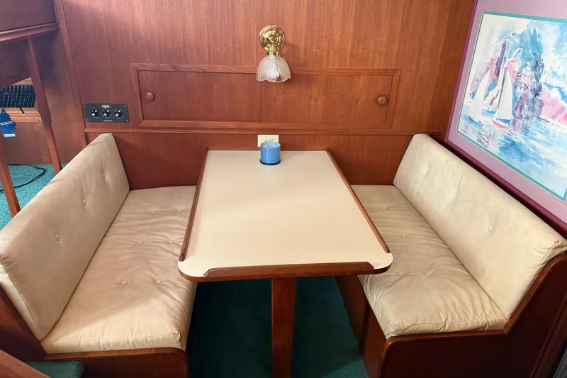 Slide: The Image of 1987 Chris-Craft 362 Catalina interior with cozy dining booth and nautical artwork. - 17