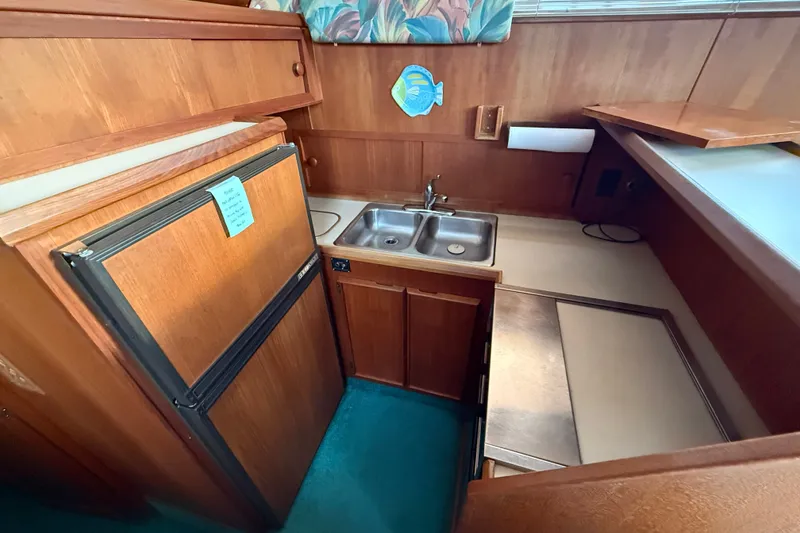Slide: The Image of 1987 Chris-Craft 362 Catalina kitchen with wood cabinetry, double sink, and refrigerator. - 15