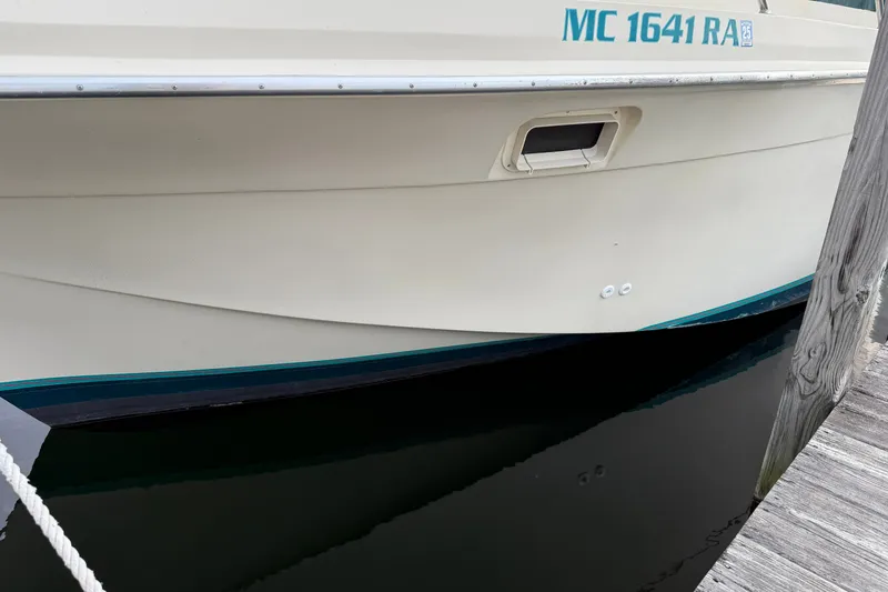 Slide: The Image of 1987 Chris-Craft 362 Catalina boat docked, showing hull and registration number. - 6