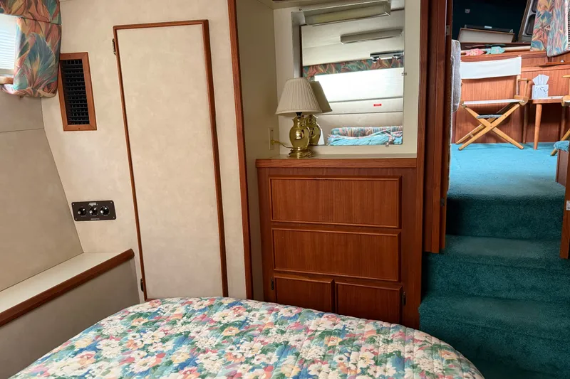 Slide: The Image of Interior of 1987 Chris-Craft 362 Catalina with floral bedding and wooden cabinetry. - 32