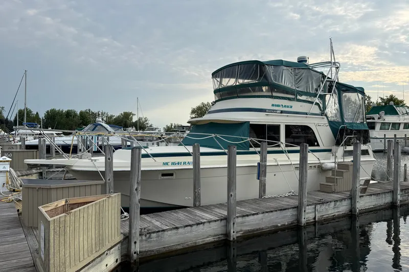 Slide: The Image of 1987 Chris-Craft 362 Catalina yacht docked at a marina under a cloudy sky. - 2