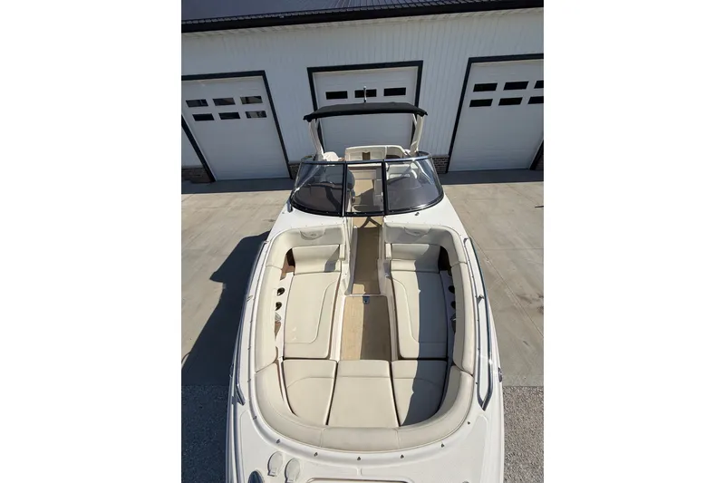 Slide: The Image of 2014 Chaparral 307 SSX boat with spacious seating, docked near a garage. - 5