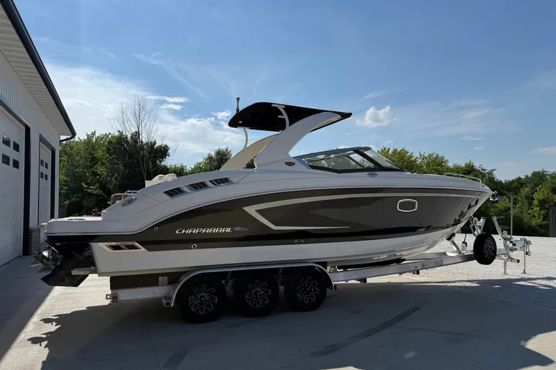 Slide: The Image of 2014 Chaparral 307 SSX boat on trailer, parked outdoors near a building. - 4