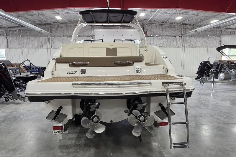 Slide: The Image of 2014 Chaparral 307 SSX boat in showroom, rear view with swim platform and ladder. - 4