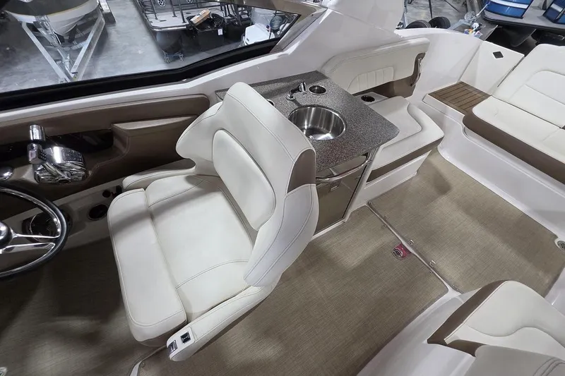 Slide: The Image of 2014 Chaparral 307 SSX boat interior with helm, seating, and sink. - 11