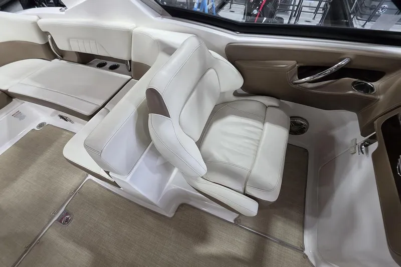 Slide: The Image of Interior seating of a 2014 Chaparral 307 SSX boat, featuring beige and white upholstery. - 12