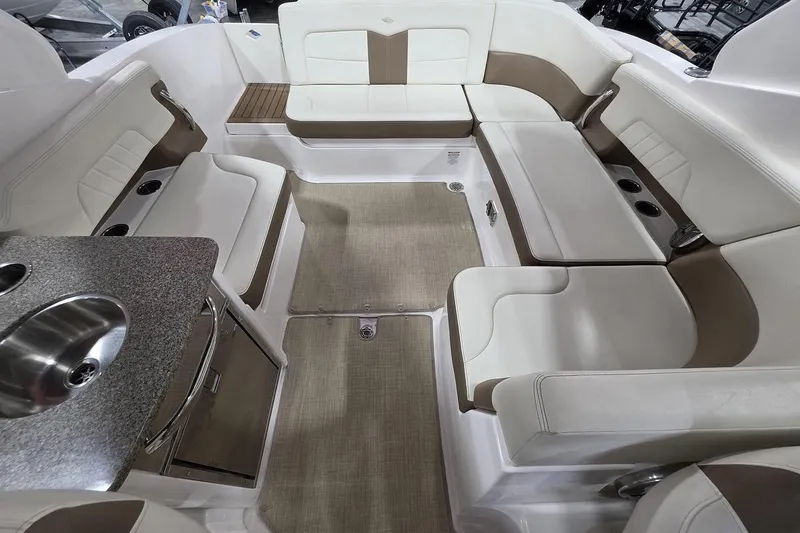 Slide: The Image of 2014 Chaparral 307 SSX boat interior with beige seating and compact kitchenette. - 10