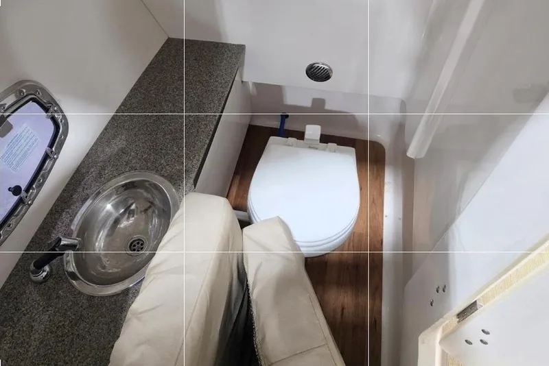 Slide: The Image of 2014 Chaparral 307 SSX boat bathroom with sink, toilet, and countertop. - 16