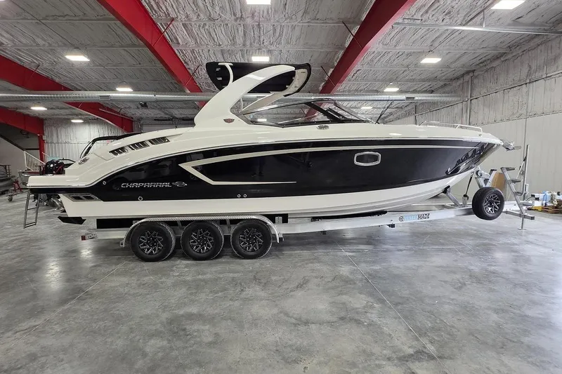 The Image of 2014 Chaparral 307 SSX boat on trailer in indoor storage facility. - 2
