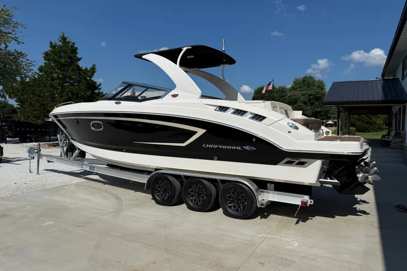 Slide: The Image of 2014 Chaparral 307 SSX boat on trailer, parked outdoors under clear blue sky. - 3
