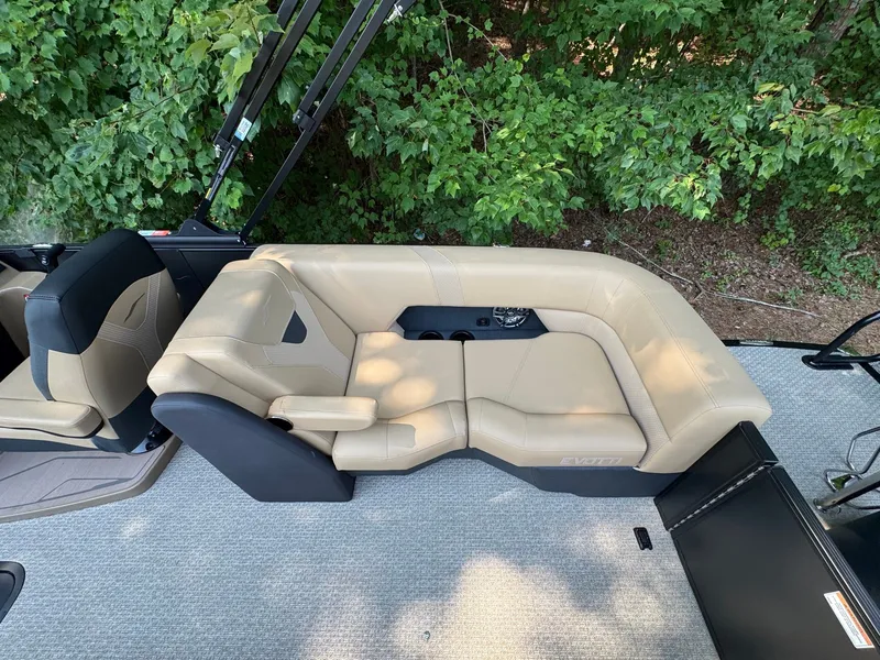 Slide: The Image of The image shows a beige leather seating area on a boat, surrounded by green trees. - 23