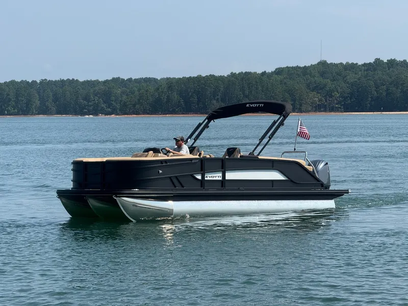 Slide: The Image of A modern pontoon boat with a black hull and sunshade cruising on a calm lake. - 4