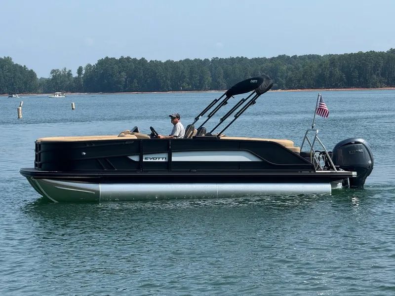 Slide: The Image of A 2027 Evotti 521QL pontoon boat on a calm lake with a driver on board. - 5