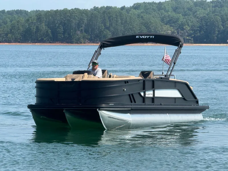 The Image of A 2027 Evotti 521QL pontoon boat cruising on a calm lake with a wooded shoreline in the background. - 1