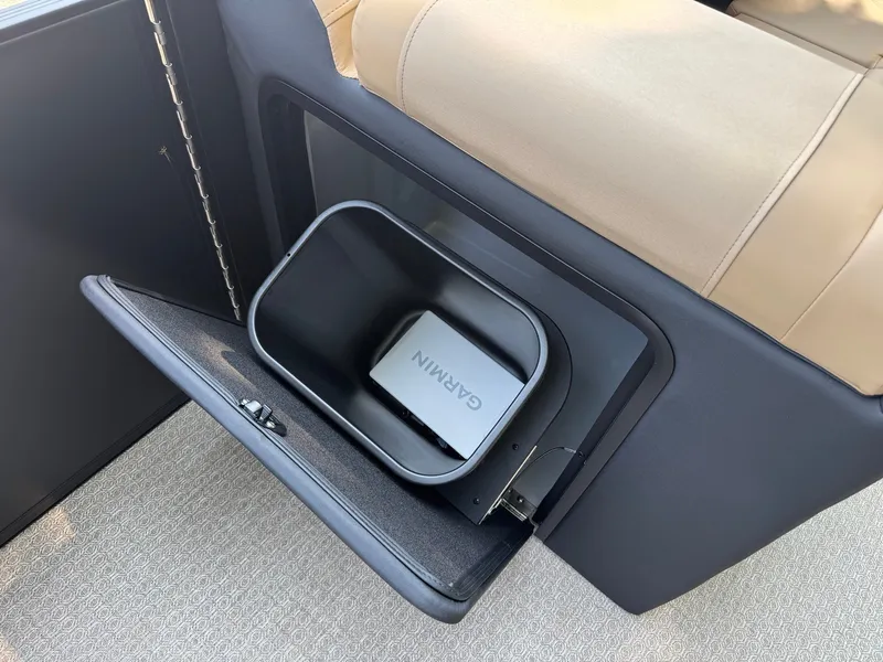 Slide: The Image of An open storage compartment with a Garmin device inside, surrounded by beige upholstery. - 17