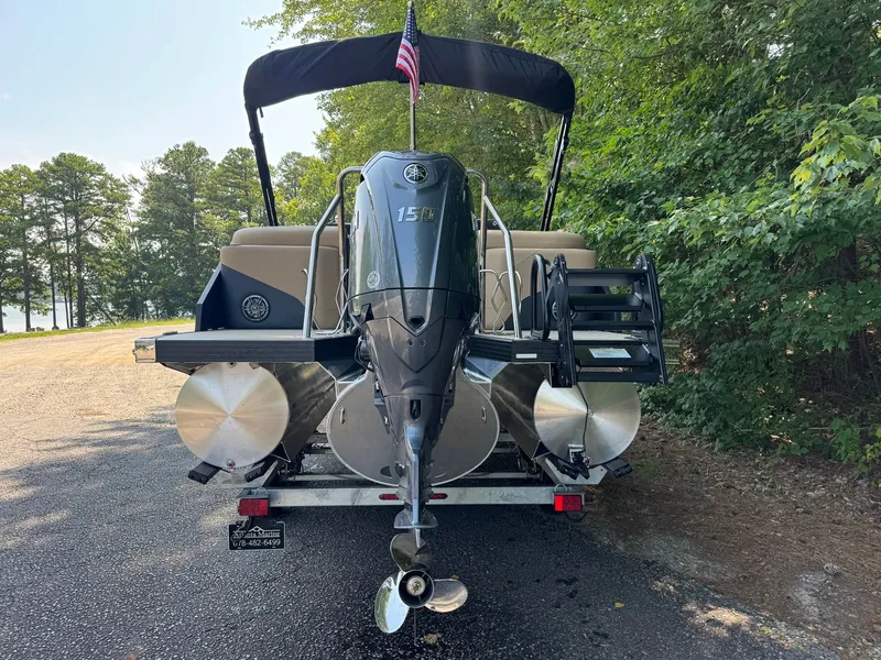 Slide: The Image of An Evotti 521QL pontoon boat with an outboard motor, on a trailer in a wooded area. - 10