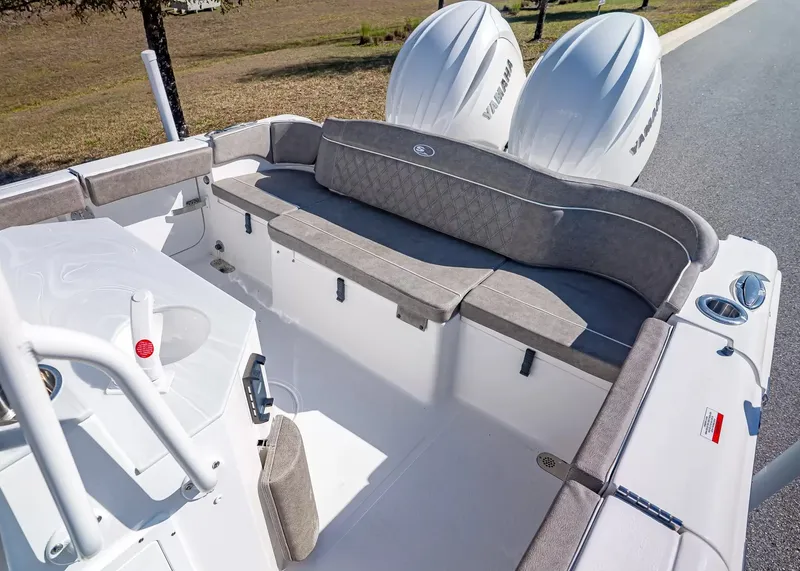 Slide: The Image of The image shows the stern of a Sea Hunt Ultra 265 SE boat with gray cushions and two outboard engines. - 7