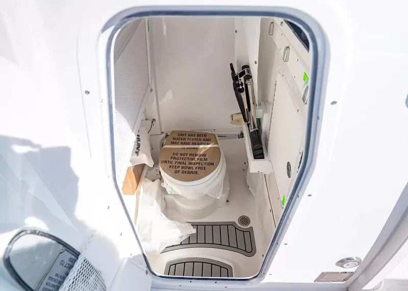 Slide: The Image of A view inside the cabin of a Sea Hunt Ultra 265 SE boat with a toilet and storage. - 20