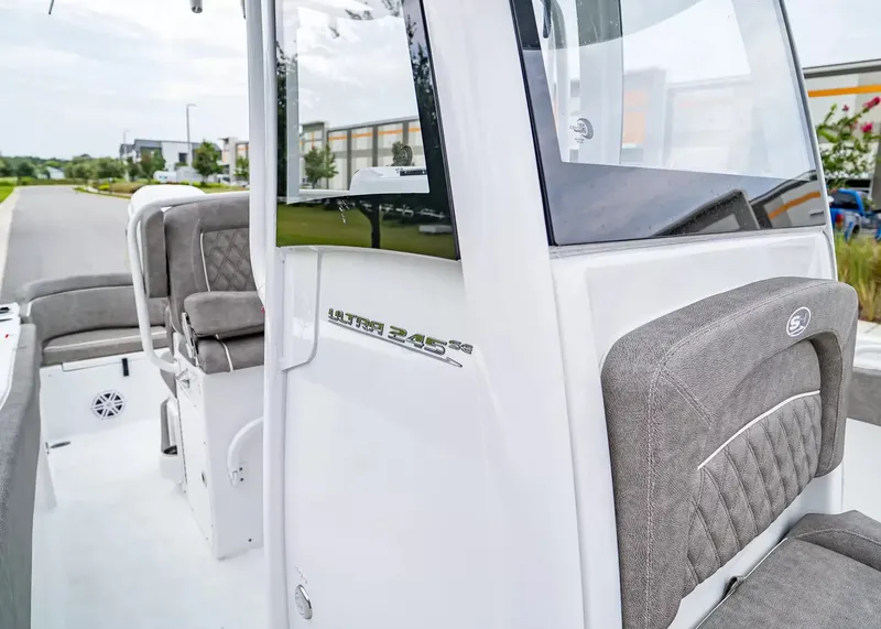 Slide: The Image of The image shows the cockpit of a Sea Hunt Ultra 245 SE boat with gray upholstery. - 20