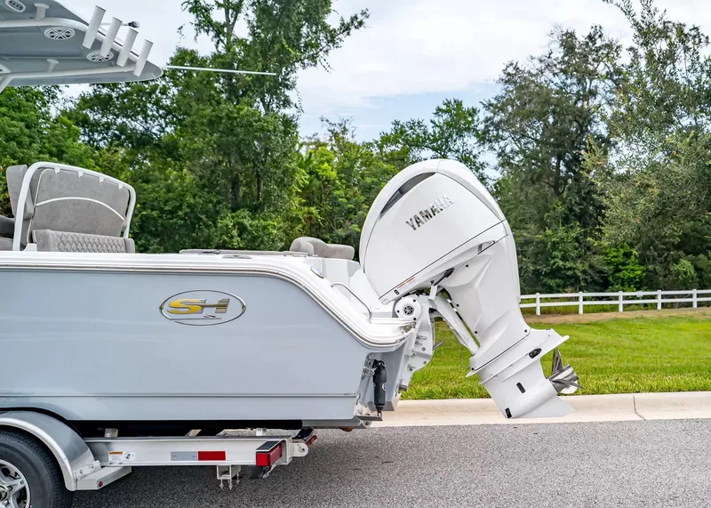 Slide: The Image of A Sea Hunt Ultra 245 SE boat with a Yamaha outboard motor, parked on a trailer. - 3