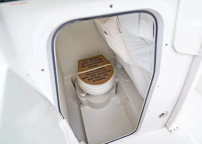 Slide: The Image of A compact toilet area with a closed toilet and a protective cover. - 21