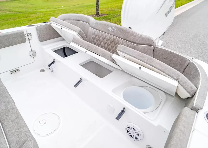 Slide: The Image of The image shows the cockpit of a 2027 Sea Hunt Ultra 245 SE boat with cushioned seats and storage. - 11