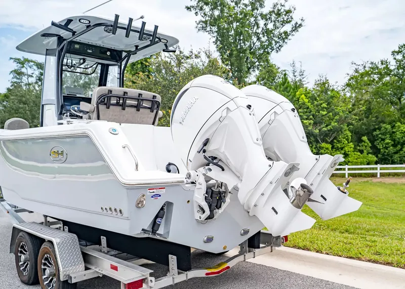 Slide: The Image of A 2026 Sea Hunt Gamefish 25 boat on a trailer with dual outboard engines. - 4