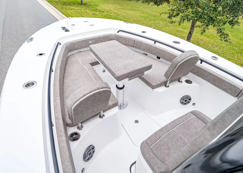 Slide: The Image of The image shows the bow area of a Sea Hunt Gamefish 25 boat with gray upholstery and a table. - 21